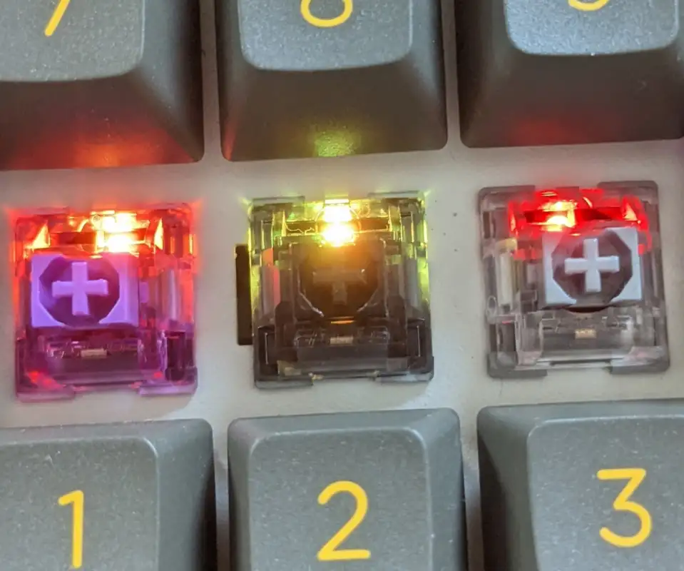 Picture of the Akko CS Silver switch next to the Jelly Black and Jelly Purple